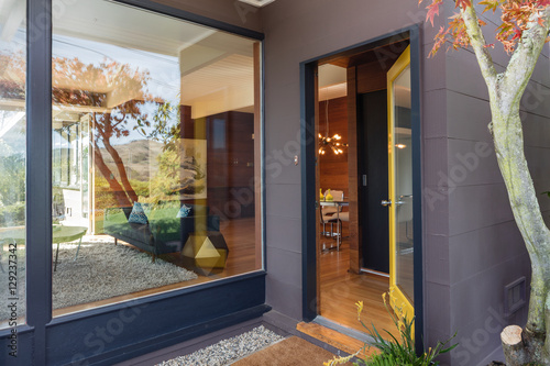 Open front door with large window next to it.