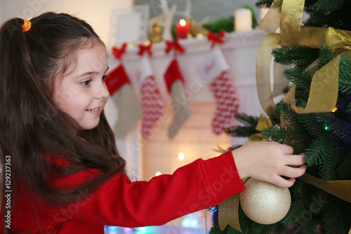 Little girl decorating Chri...