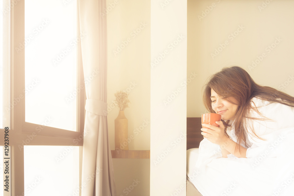 Happy beautiful young Asian woman smile while enjoy drinking coffee in morning in bed room. Happy beautiful young Asian woman smile while enjoy drinking coffee in morning in bed room.