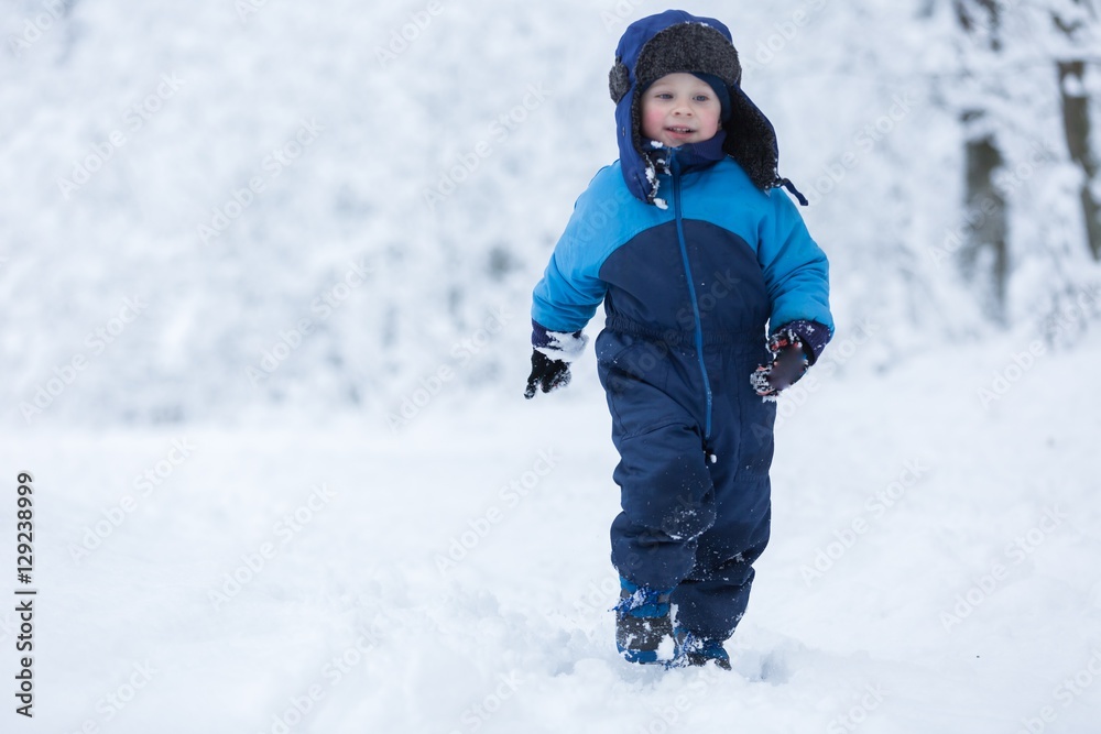 Happy caucasian child playing in snow