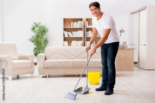 Man cleaning home with broom