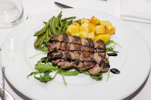 Sliced beef with balsamic vinegar and roasted potatoes photo