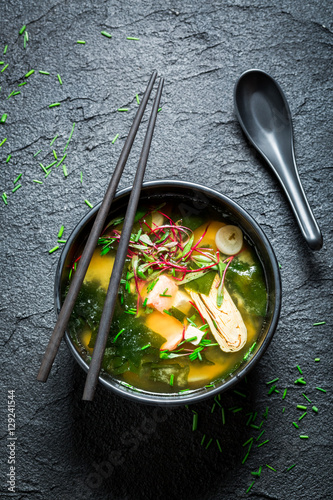 Tasty miso soup with salmon in black bowl