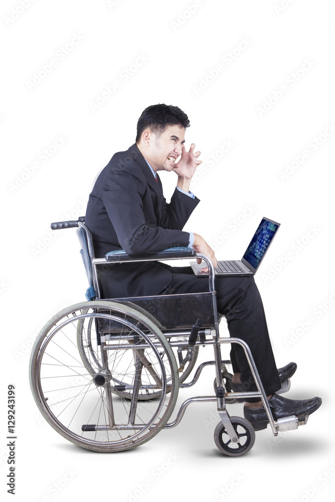 Businessman with laptop and wheelchair on studio