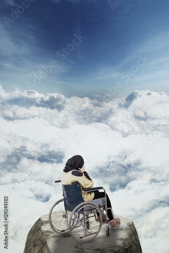 Disabled woman looks depressed on the mountain © Creativa Images