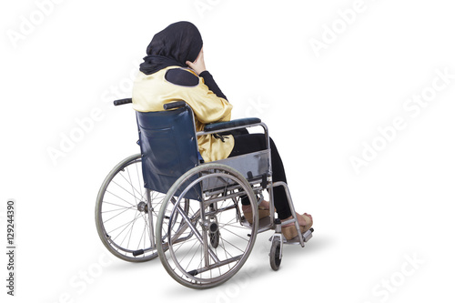 Disabled woman looks sad with a wheelchair © Creativa Images