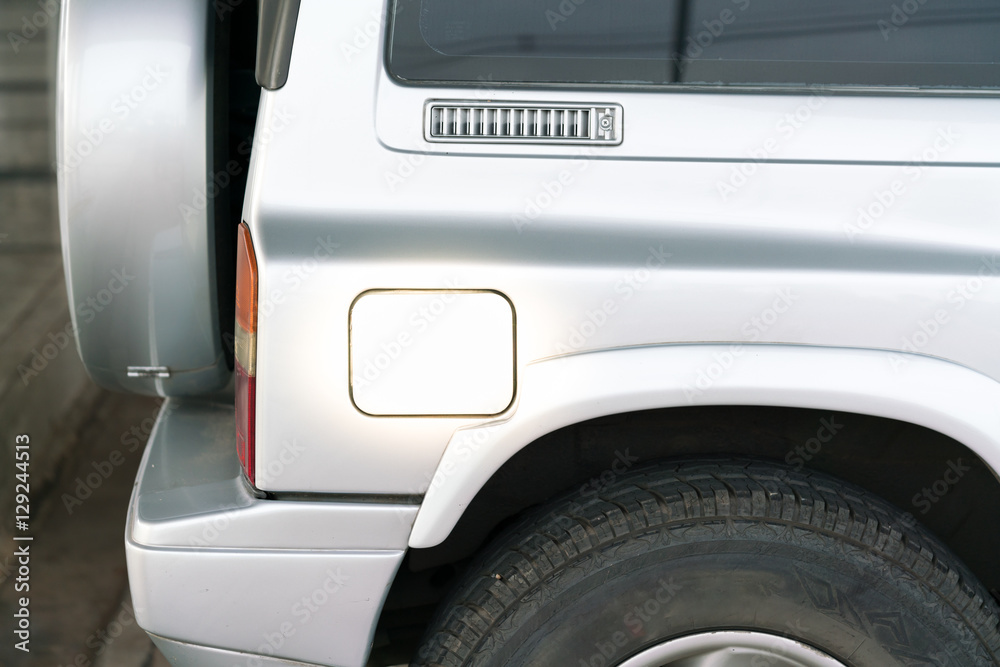 petrol cap cover of a silver car with copy space - fuel tank