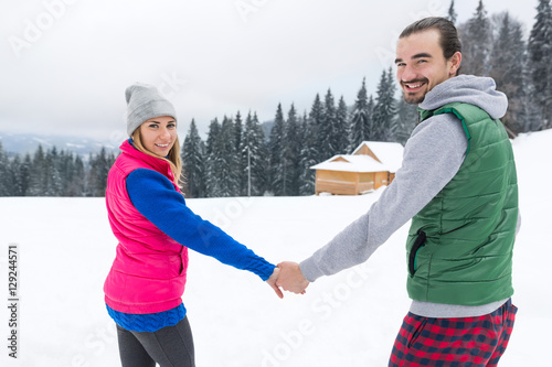 Young Couple Snowy Village Wooden Country House Man And Woman Winter Snow Resort Cottage Holiday Vacation