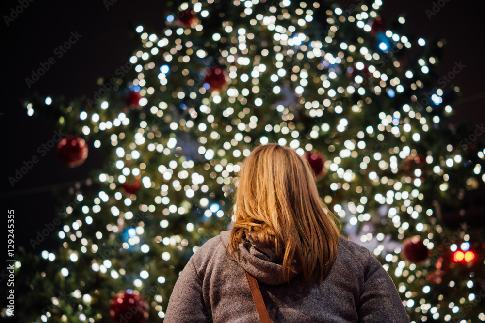 A Woman Looks At Christmas Tree At Night A Woman Looks At Christmas Tree At Night