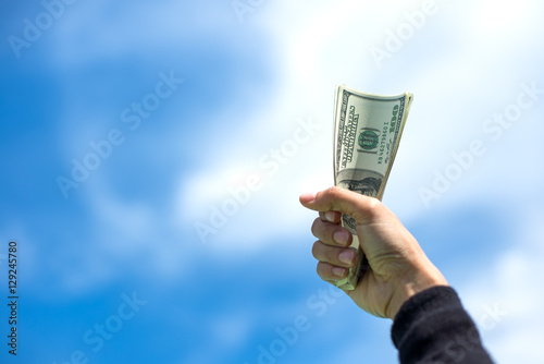 Money in the hand, background blue sky