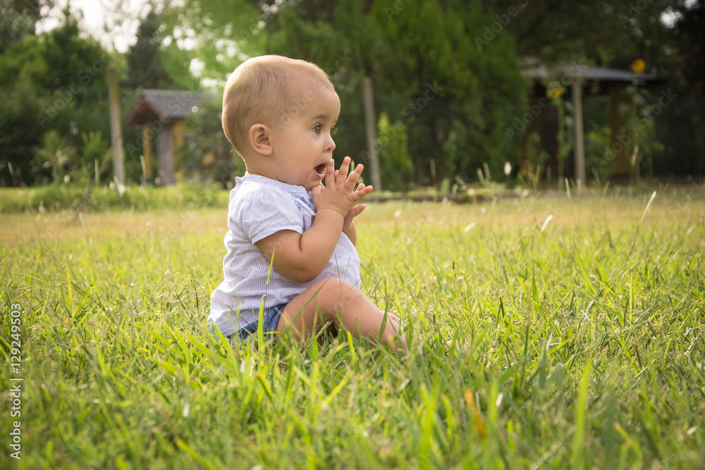 happy young baby child sittng on grass on beautiful summer day i happy young baby child sittng on grass on beautiful summer day i