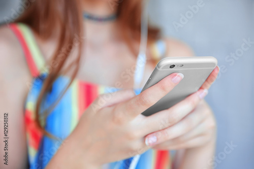 Teenage girl listening to music with headphones and smartphone, close up