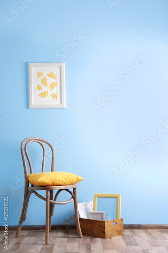 Simple interior with stool and painting on blue wall background