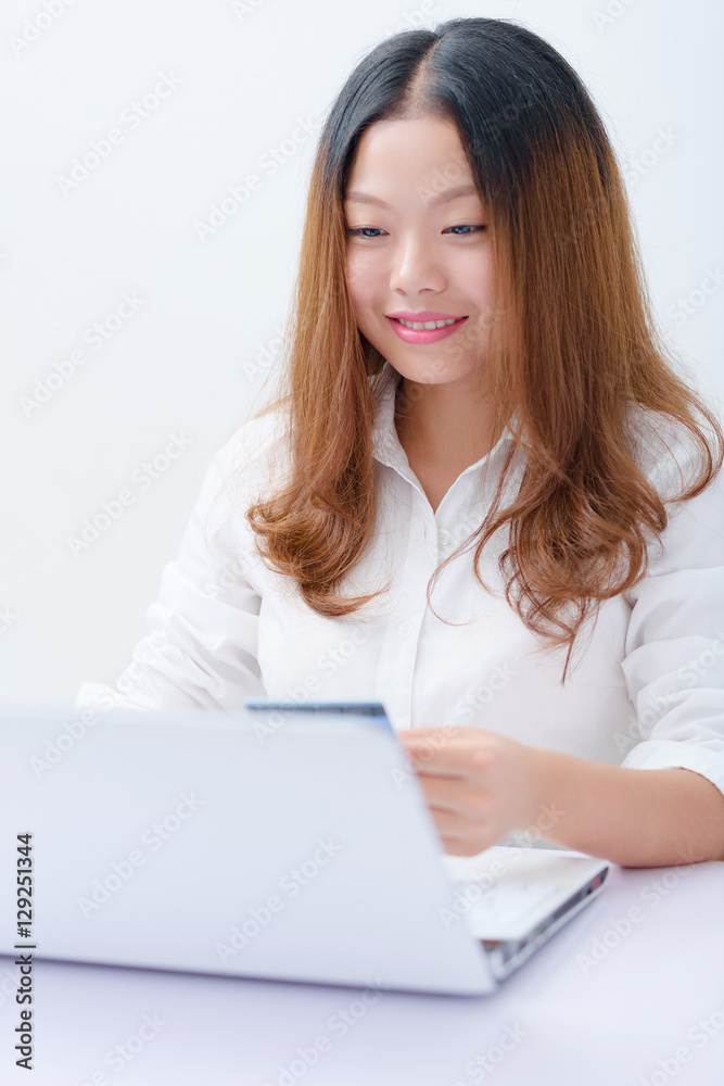 Young woman using credit card paying on laptop. Young woman using credit card paying on laptop.