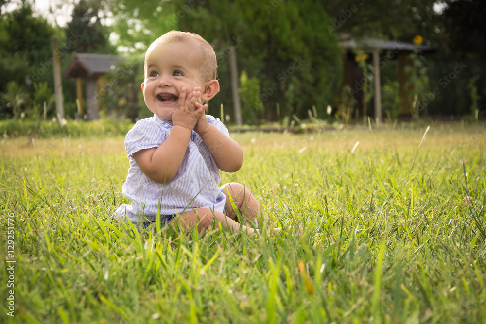 happy young baby child sittng on grass on beautiful summer day i happy young baby child sittng on grass on beautiful summer day i