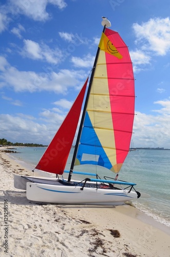 Small sailing catamaran available for rent resting in the sand at a beach on Key Biscayne ,Florida