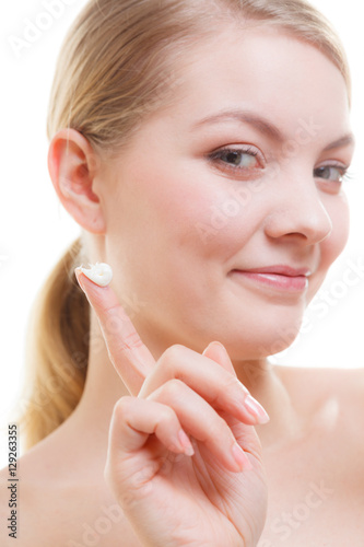 Woman applying face cream with her finger