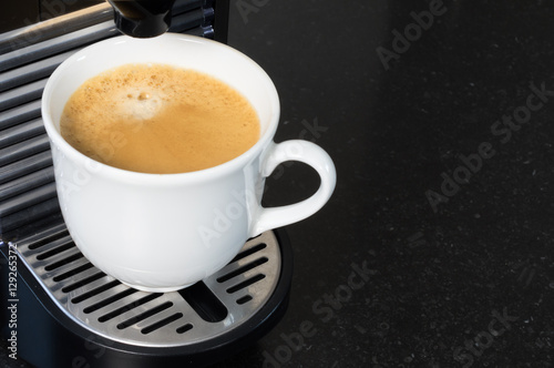 Freshly brewed creamy coffee from espresso machine.