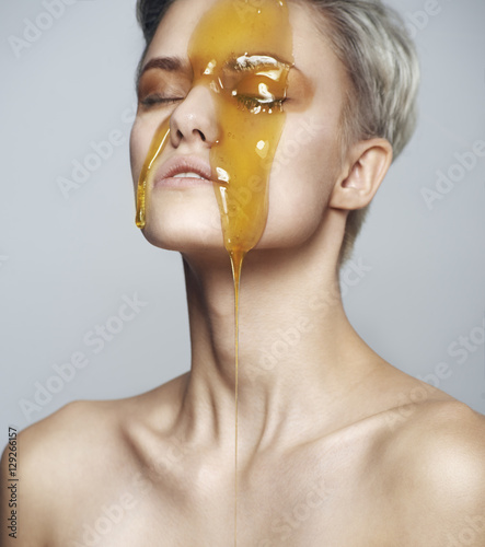 Beautiful woman with a honey on her face