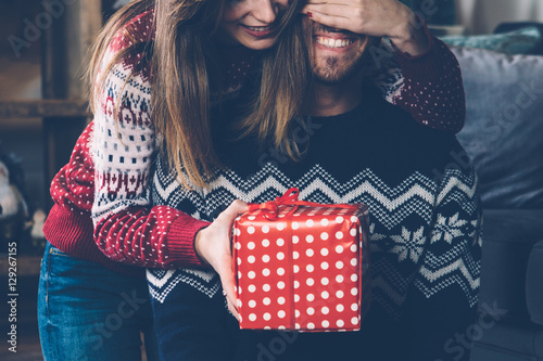 Woman giving Christmas gift to beloved