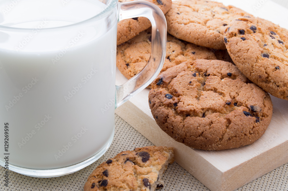 Transparent cup with milk and oatmeal cookies Transparent cup with milk and oatmeal cookies
