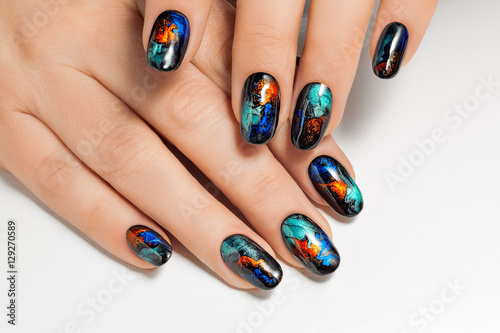 Female hands with New Year design on the nails holding snowflake.Isolated.