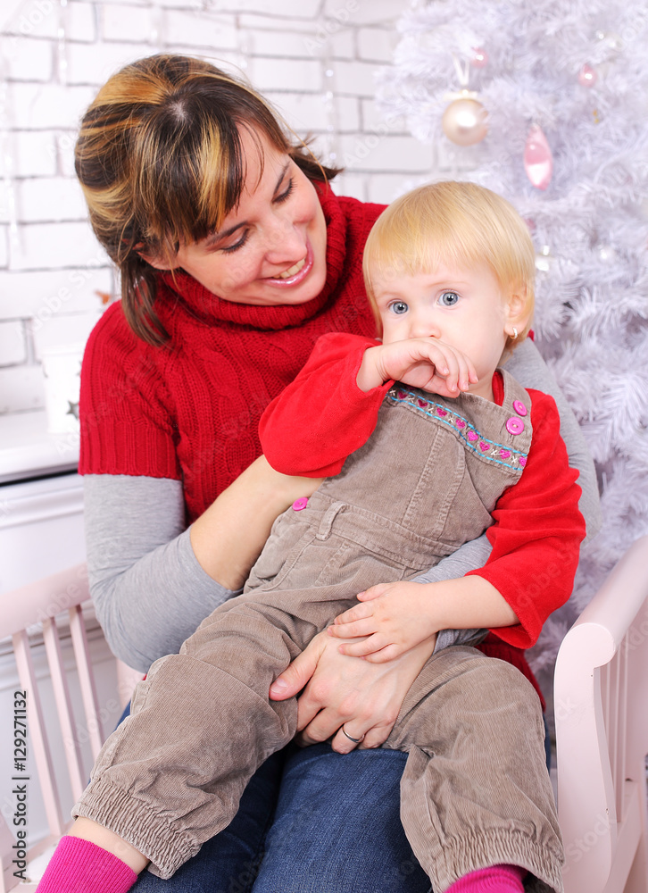 Beauty woman and child sit indoor at christmas decoration Beauty woman and child sit indoor at christmas decoration