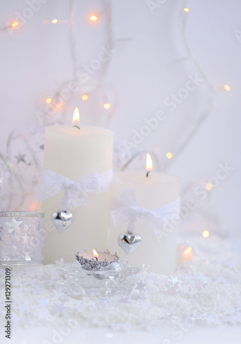 Christmas candles on the snow and Christmas lights. Festive Christmas background