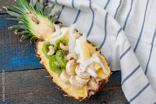 Cut in half pineapple with coconut, chia, kiwi, cashew. Perfect for the dessert diet or just a healthy meal.  Love for a healthy raw food concept.