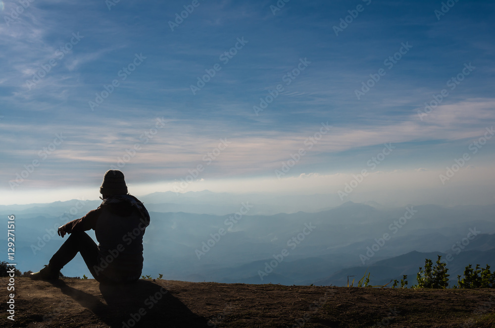 silhouette of a man who sitting and looking over the mountains l