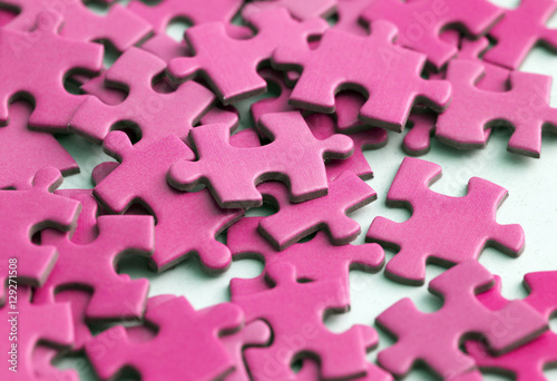Pink puzzle pieces on a white surface.