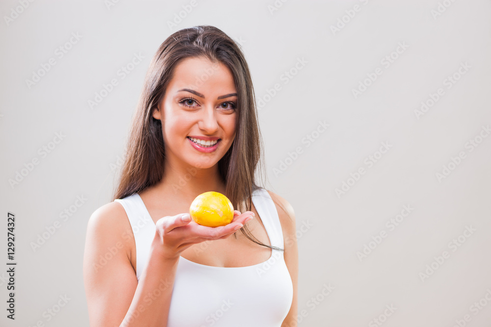Beautiful young woman is holding lemon and smiling. Beautiful young woman is holding lemon and smiling.
