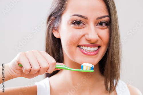 Young woman holding toothbrush. Dental hygiene concept. 