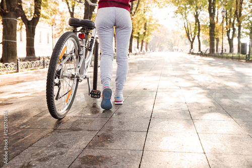 Cropped photo of woman walking with her bicycle