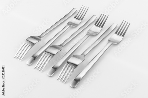 Modern silverware or flatware set isolated on white. Different shapes merged together. Image taken from above, top view