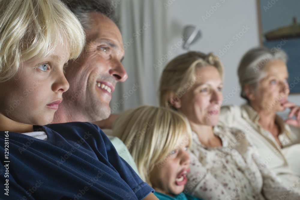 Multigenerational family sitting together and watching TV Multigenerational family sitting together and watching TV