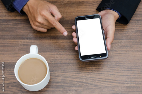 Businessman holding smartphone and coffee