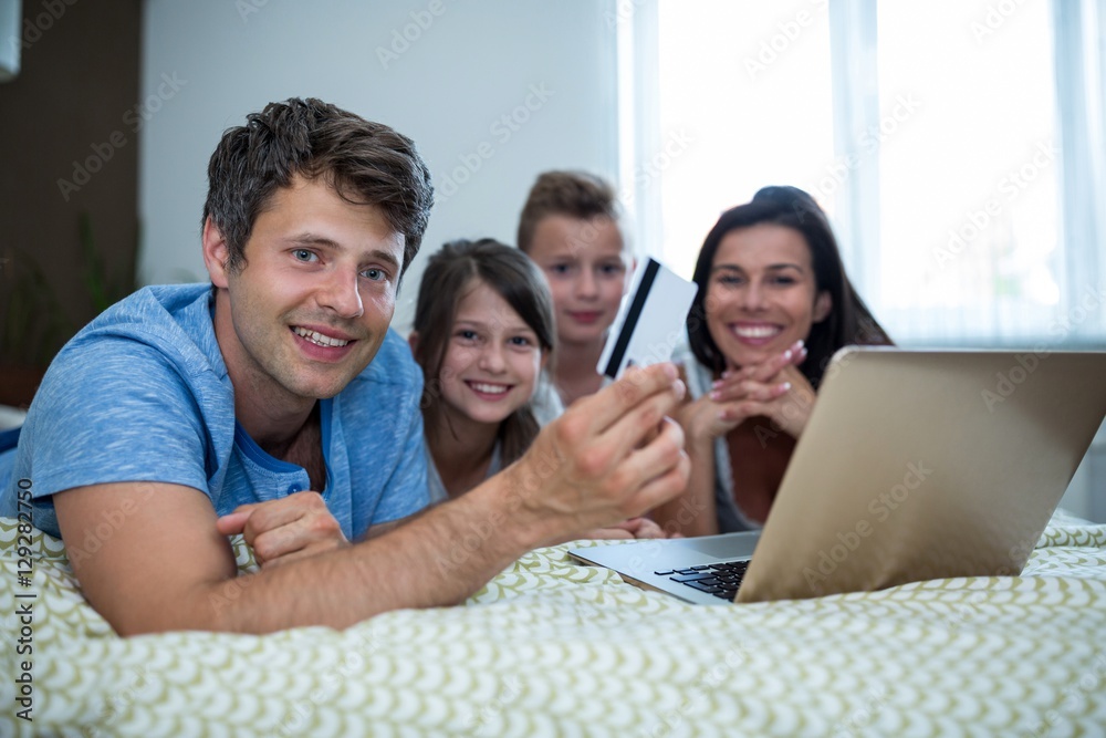 Fototapeta premium Family doing online shopping on laptop in bedroom at home