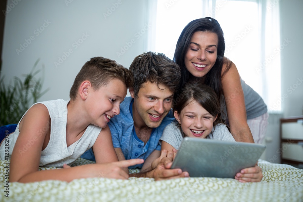 Happy family using digital tablet in bedroom Happy family using digital tablet in bedroom