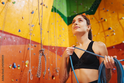 Joyful woman using climbing equipment