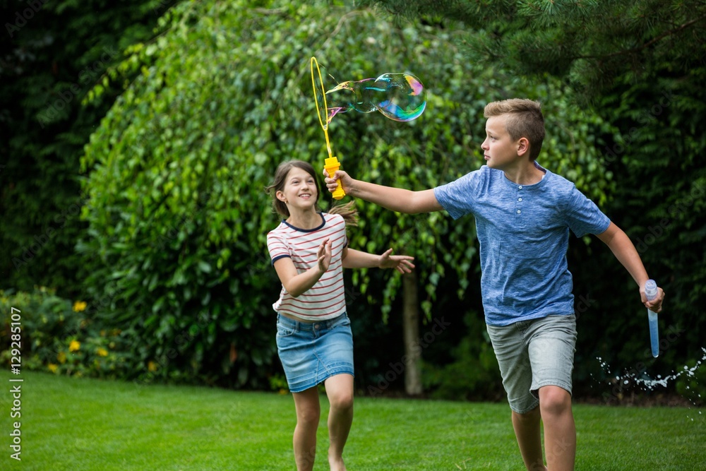 Obraz premium Kids playing with bubbles in the park