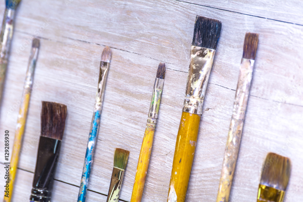 Obraz premium Artistic paintbrushes on artist canvas covered with oil paints
