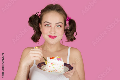 happy pretty girl with sweet dessert on pink background