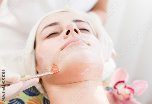  Face mask.Beautiful young girl at cosmetics getting facial treatment