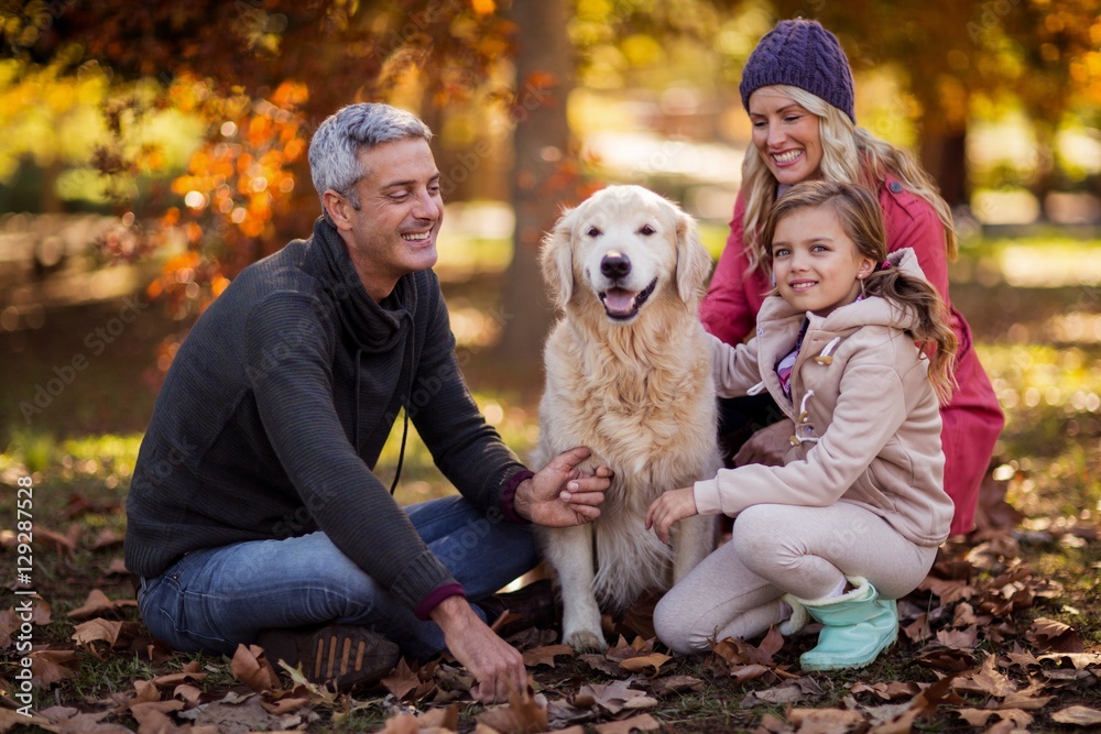 Family sitting with dog at park Family sitting with dog at park