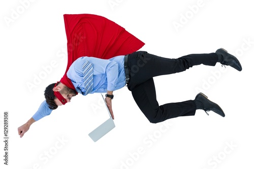 Businessman pretending to be a super hero holding laptop