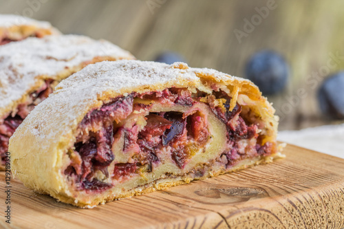 Detailed Front View on Plum strudel on wood plank timber photo