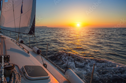 Sailing boat during amazing sunset on the sea.