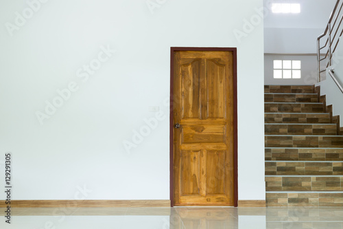 white empty room interior with wooden door and staircase