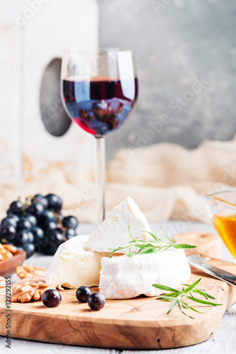 Brie cheese and slice on a wooden board